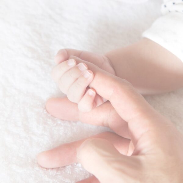 Baby grips grandma’s hand